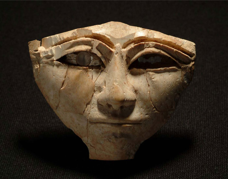 Qatna_AppliqueOrnament.jpg - Appliqué ornament representing a human face in Egyptianising style (ca. 1400-1300 BC)‎, Qatna, Syria