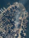 One-meter resolution satellite image of Manhattan, New York was collected at 11:54 a.m. EDT on Sept. 15, 2001 by Space Imaging's IKONOS satellite. The image shows the remains of the 1,350-foot towers of the World Trade Center, and the debris and dust that has settled throughout the area. Also visible are the many emergency and rescue vehicles in the streets in the vicinity of the disaster.